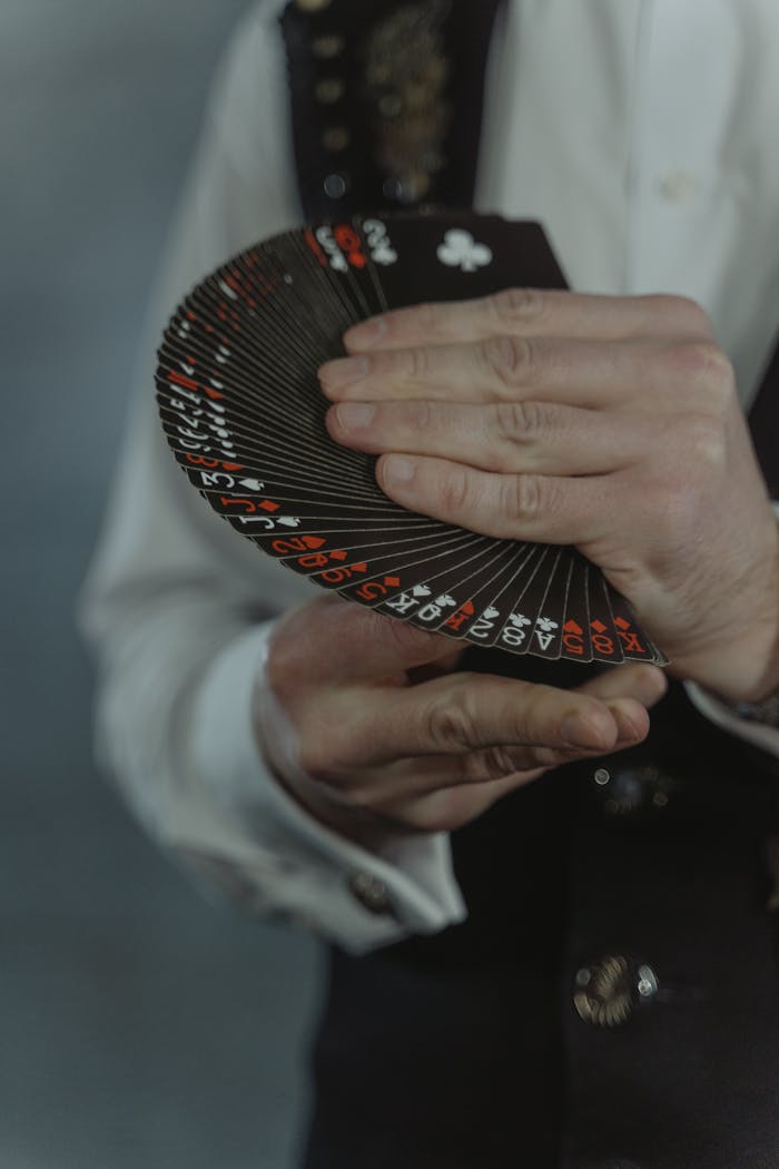 Offerings An illusionist elegantly displaying a fan of black playing cards during a magic performance.
